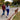 Couple walks their dog in autumn park using a hands-free dog leash, enjoying a relaxed stroll with colourful fall leaves.