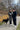 Couple walking their dog on a cold winter morning, using a hands-free belt and leash while enjoying a cup of coffee.