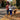 Couple walking dog with hands-free dog leash belt on an autumn street covered in colorful leaves for safe relaxed strolls.