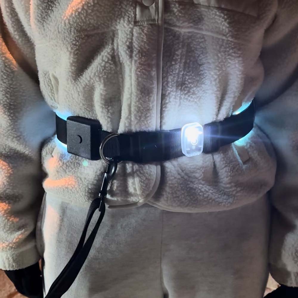 Person wearing a light-up hands-free dog leash at night, enhancing safety and visibility during dog walks.